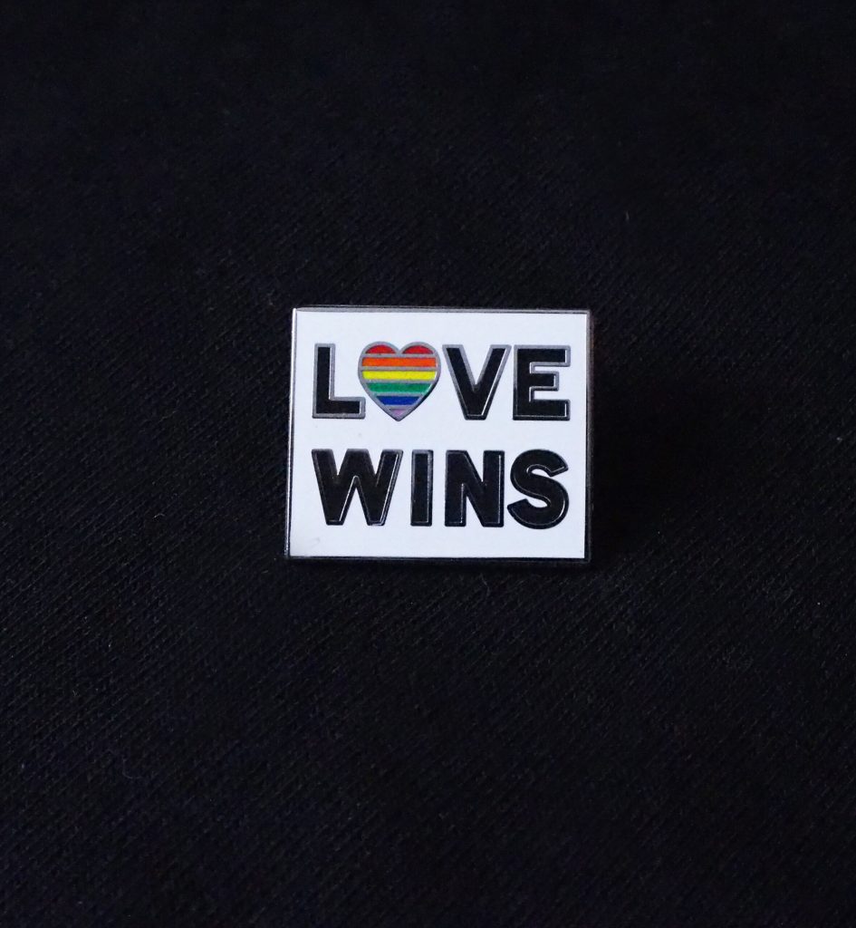 Firkantet pin med teksten LOVE WINS